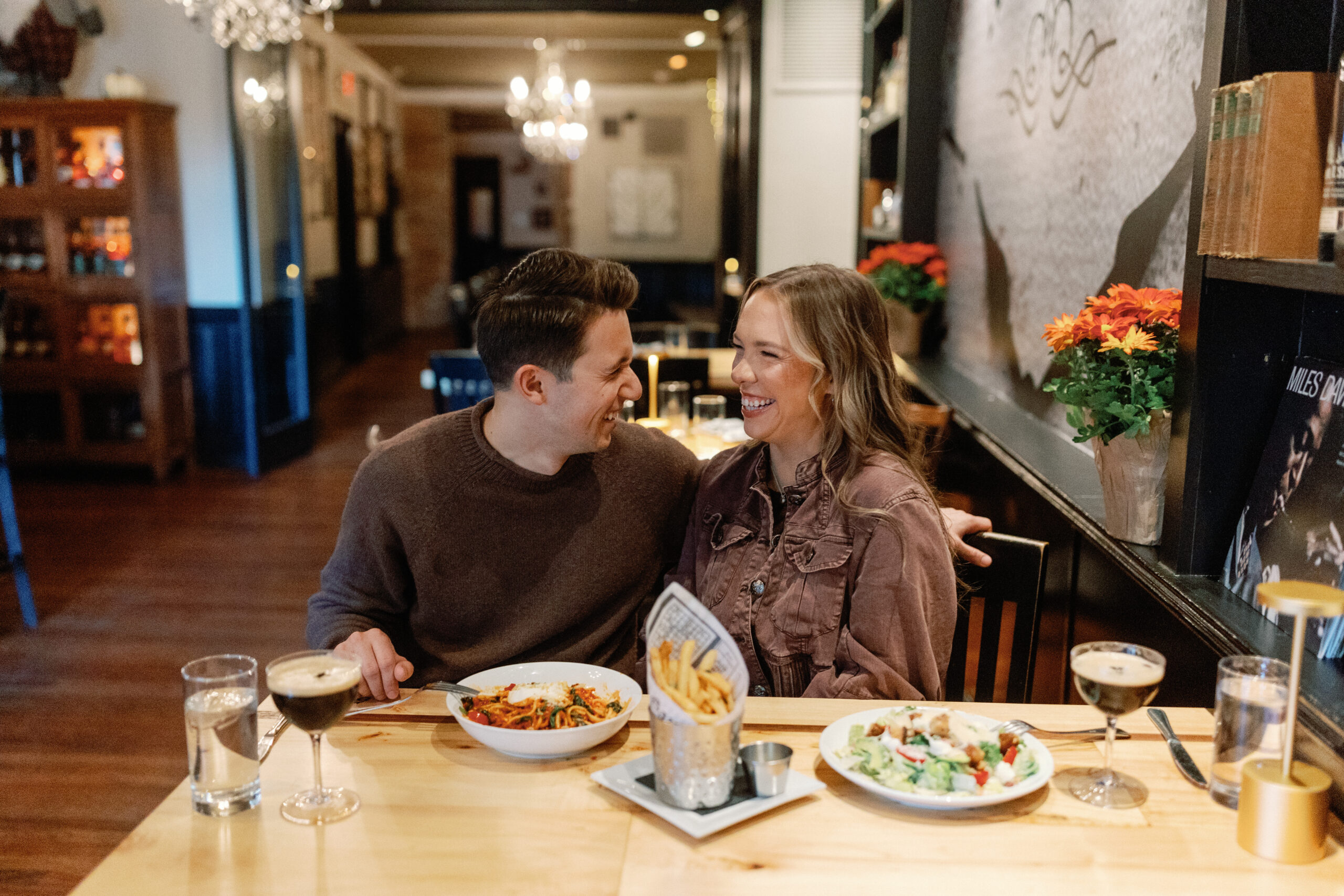 A couple enjoying their engagement session in downtown West Chester, Pennsylvania, sharing a moment over espresso martinis at Bar Avalon, walking along Gay Street, and enjoying gelato at D’Ascenzo’s, with their dog Nova making a brief appearance